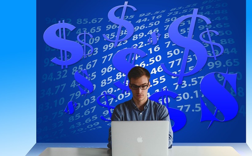 man working on a laptop with dollar icons on background